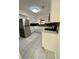 Updated kitchen featuring white cabinets, stainless steel appliances, and stylish backsplash on light floors at 2400 13Th S Ave, St Petersburg, FL 33712