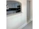 Modern kitchen with white cabinets, black backsplash, and stainless steel appliances viewed through archway at 2400 13Th S Ave, St Petersburg, FL 33712