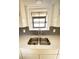 Stainless steel kitchen sink featuring modern faucet and herringbone tile backsplash beneath window at 2400 13Th S Ave, St Petersburg, FL 33712