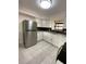 Bright kitchen with stainless steel refrigerator, white cabinets, tile floors, and herringbone tile backsplash at 2400 13Th S Ave, St Petersburg, FL 33712