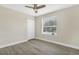 This bedroom has neutral paint, light wood-look floors, a ceiling fan and natural light at 27330 Coral Springs Dr, Wesley Chapel, FL 33544