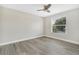 A bright bedroom with modern ceiling fan, a window, and wood-look flooring at 27330 Coral Springs Dr, Wesley Chapel, FL 33544