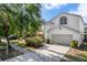 Charming two-story home featuring a two-car garage, arched windows, and mature landscaping at 27330 Coral Springs Dr, Wesley Chapel, FL 33544