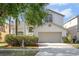 Charming two-story home featuring a two-car garage, arched windows, and mature landscaping at 27330 Coral Springs Dr, Wesley Chapel, FL 33544