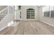 Bright, airy living room with large windows, luxury vinyl flooring, and neutral paint at 27330 Coral Springs Dr, Wesley Chapel, FL 33544