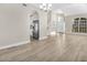 Bright, airy living room featuring luxury vinyl flooring, stairs, and an open kitchen concept at 27330 Coral Springs Dr, Wesley Chapel, FL 33544