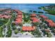 Aerial view of community featuring sparkling pool, lush landscaping, and waterfront views at 2755 Via Capri # 1223, Clearwater, FL 33764