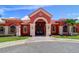 Stunning entrance with red facade, arched doorway, tile roof, and decorative accents at 2755 Via Capri # 1223, Clearwater, FL 33764