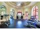 Well-equipped gym with machines, weights, rubber floor, and large arched windows at 2755 Via Capri # 1223, Clearwater, FL 33764