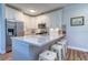 Well lit kitchen with stainless steel appliances, white cabinets, and a breakfast bar with stools at 2755 Via Capri # 1223, Clearwater, FL 33764