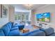 Cozy living room featuring a comfortable blue sectional sofa, natural light, and a dining area at 2755 Via Capri # 1223, Clearwater, FL 33764