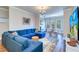 Bright living room featuring a blue sectional sofa, a dining area by a bay window, and a mounted television at 2755 Via Capri # 1223, Clearwater, FL 33764
