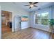 Living room with a TV, wood floors, and a view of lush greenery from the large window at 2755 Via Capri # 1223, Clearwater, FL 33764