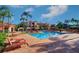 Resort-style pool with lounge chairs, palm trees, and multi-story condo buildings at 2755 Via Capri # 1223, Clearwater, FL 33764