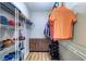 Organized walk-in closet with shelving, hanging clothes, and center drawers on wood floor at 2755 Via Capri # 1223, Clearwater, FL 33764