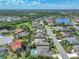 Wide aerial capturing a peaceful neighborhood with a lake, lined with trees and greenery, offering a serene backdrop for residential life at 2908 89Th E Ave, Parrish, FL 34219