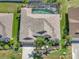 High-angle view highlights a home's well-kept yard, vibrant landscaping, and a refreshing screened-in pool area at 2908 89Th E Ave, Parrish, FL 34219