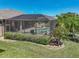 An aerial view of a screened-in pool with spa, patio seating and lush landscaping and hardscape at 2908 89Th E Ave, Parrish, FL 34219