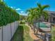 Landscaped backyard featuring a screened pool area, manicured lawn, and mature trees at 2908 89Th E Ave, Parrish, FL 34219