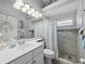 Bright bathroom with a large mirror, decorative lighting, and a tiled shower with pebble flooring at 2908 89Th E Ave, Parrish, FL 34219