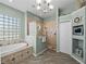 Bright bathroom with a soaking tub, glass block window, and walk-in shower with nautical accents at 2908 89Th E Ave, Parrish, FL 34219