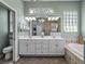 Well-lit bathroom with a double vanity, shower, and soaking tub with tiled walls and flooring at 2908 89Th E Ave, Parrish, FL 34219