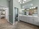 Coastal bathroom featuring double sink vanity, wood-look tile flooring, and decorative nautical accents at 2908 89Th E Ave, Parrish, FL 34219