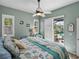 Bedroom with a ceiling fan, coastal decor, and sliding doors leading to a screened-in pool area at 2908 89Th E Ave, Parrish, FL 34219