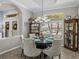 Elegant dining room with a glass-topped table set for dinner and decorative display cabinets at 2908 89Th E Ave, Parrish, FL 34219