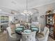 Bright dining room with open floorplan, decorative chandelier, with view to living room and pool at 2908 89Th E Ave, Parrish, FL 34219