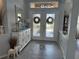 Elegant entryway featuring double glass doors, decorative transom window, and stylish console table with mirror at 2908 89Th E Ave, Parrish, FL 34219