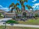 Beautiful single-Gathering home with lush landscaping, mature palms, and a well-maintained lawn under a clear sky at 2908 89Th E Ave, Parrish, FL 34219