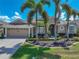 Attractive single-Gathering home featuring mature palm trees, colorful landscaping, and a well-maintained lawn and driveway at 2908 89Th E Ave, Parrish, FL 34219