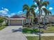 Beautiful home featuring mature palm trees, lush landscaping, a two-car garage, and a well-maintained lawn at 2908 89Th E Ave, Parrish, FL 34219