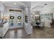 Inviting foyer with decorative double doors, an elegant accent table, and a view into the formal dining area at 2908 89Th E Ave, Parrish, FL 34219