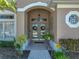 Home's inviting front entrance features double doors, decorative details, and a well-maintained landscape at 2908 89Th E Ave, Parrish, FL 34219