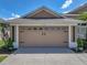 Attached two-car garage featuring decorative windows and dark hardware at 2908 89Th E Ave, Parrish, FL 34219