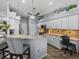 Stylish kitchen showcasing white cabinetry, granite countertops, tile backsplash, and a dedicated desk area at 2908 89Th E Ave, Parrish, FL 34219
