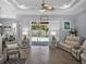 Open living room with a view of the pool, stylish furnishings, and wood-look tile flooring at 2908 89Th E Ave, Parrish, FL 34219