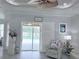 Bright living room featuring sliding glass doors to the pool area, a ceiling fan, and neutral decor at 2908 89Th E Ave, Parrish, FL 34219