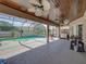 Spacious covered patio featuring a well-equipped outdoor kitchen and a comfortable seating area by the pool at 2908 89Th E Ave, Parrish, FL 34219