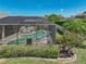 Relaxing pool area with screened-in lanai, lounge chairs, and lush green surroundings at 2908 89Th E Ave, Parrish, FL 34219