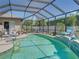 Enclosed pool with a waterfall feature, surrounded by manicured landscaping for a private oasis at 2908 89Th E Ave, Parrish, FL 34219