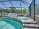 Screened-in pool with a dolphin water feature and comfortable lounge chairs, perfect for outdoor enjoyment at 2908 89Th E Ave, Parrish, FL 34219