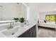 Bright bathroom with double sink vanity, modern mirror, and view to bedroom at 2953 Yucca Ct, Palm Harbor, FL 34684