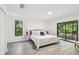 The bedroom has a large window, sliding glass doors to a screened in porch and neutral decor at 2953 Yucca Ct, Palm Harbor, FL 34684