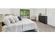 Bright bedroom with patterned bedding, wood-look floors, and a black dresser at 2953 Yucca Ct, Palm Harbor, FL 34684