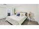 Bedroom with gray headboard bed, wood-look floors, and a window at 2953 Yucca Ct, Palm Harbor, FL 34684
