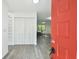 Bright entryway with wood-look flooring, closet, and a red front door for a pop of color at 2953 Yucca Ct, Palm Harbor, FL 34684