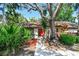 Charming single-story home featuring mature landscaping and a vibrant red front door at 2953 Yucca Ct, Palm Harbor, FL 34684